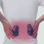 a person clutching their lower back with highlighted abdominal area indicating potential kidney-related discomfort