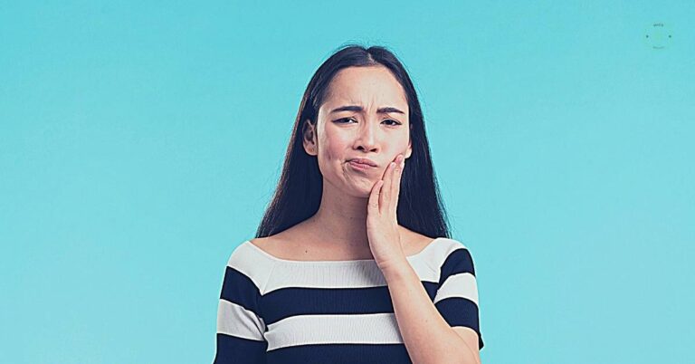 a person touching their cheek in discomfort, indicating tooth sensitivity or toothache pain on contact