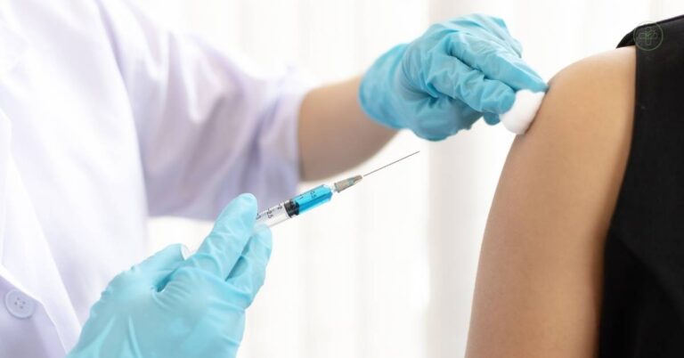 a medical professional administering an injection into someone’s upper arm with a syringe, showing a common vaccination process.
