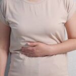 Máte Bolest V Pravém Podbříšku? 11 Nejčastějších Důvodů! 12 a person holding their right lower abdomen indicating possible symptoms of right lower abdominal pain