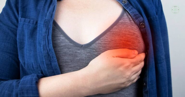 a person holding their chest area where redness and potential breast inflammation or discomfort is visible.