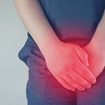 Co Pomáhá Na Bolest Varlat & 10 Nejčastějších Příčin Bolesti! 18 a person holding their lower abdomen and groin area indicating discomfort or bolest varlat.