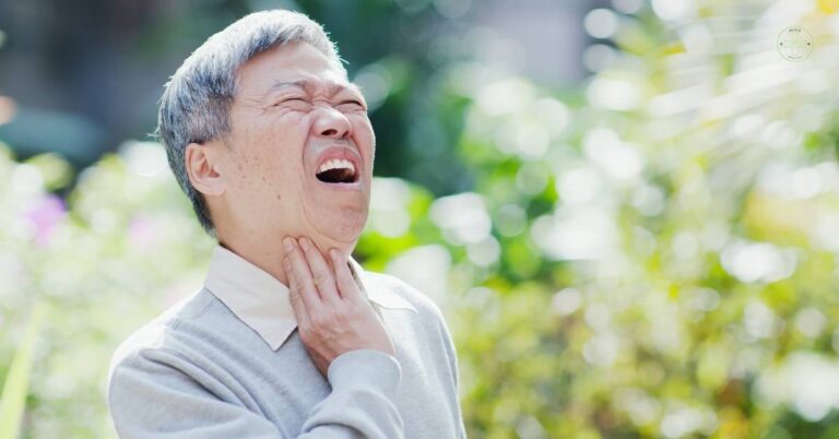an elderly man holding his throat while experiencing noticeable discomfort, possibly indicating pain during swallowing.