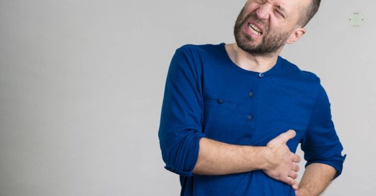 a man clutching left upper abdomen area in pain, grimacing intensely