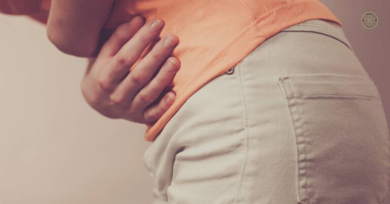 a person holding their lower abdomen near the navel area indicating possible abdominal pain around the umbilicus