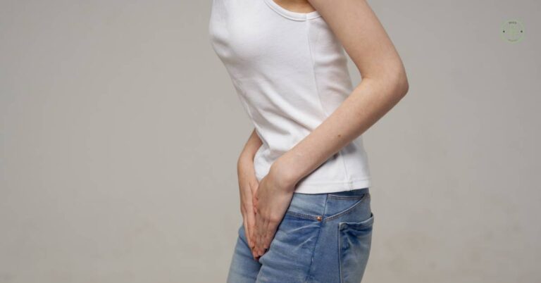 a woman holding her right groin area indicating potential pain or discomfort in the třísel region