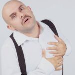 Píchání/Bolest U Srdce Nemusí Znamenat Infarkt Myokardu! 11 a bald man clutching his chest with a surprised expression, illustrating possible píchání u srdce.