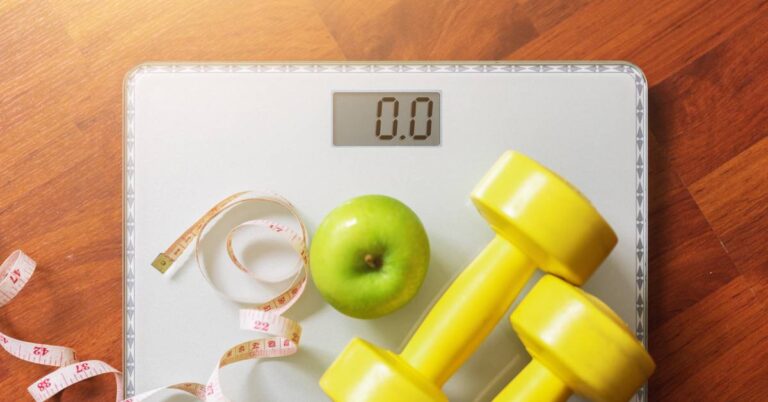 TDEE Kalkulkulačka Pro Výpočet Denního Příjmu Kalorií Pro Hubnutí, Nabrání Svalů i Udržení Vaší Váhy! 3 a digital bathroom scale showing zero weight with a green apple, yellow dumbbells, and a measuring tape for tracking denní příjem kalorií a celkový energetický výdej