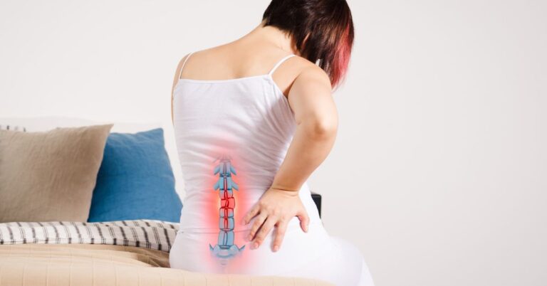a person experiencing lower back pain near the sacrum while demonstrating manual mobilization of the sacroiliac region.