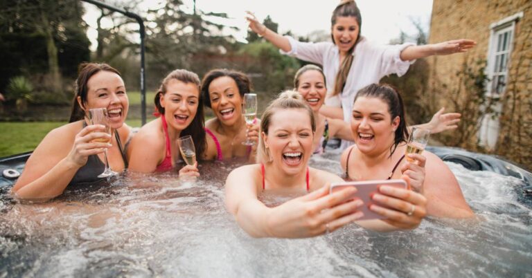 Klasická versus nafukovací vířivka: Porovnání výhod a nevýhod 4 a group of people enjoying a hot tub with champagne glasses, celebrating in an outdoor setting.