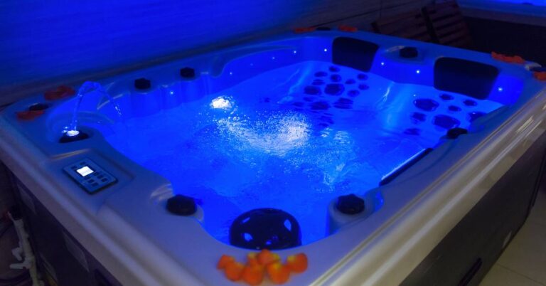 Jaký je nejlepší filtr do vířivky a jak se něj správně se starat? 2 a modern hot tub with illuminated blue lighting, jets, and control panel for maintaining clean, relaxing water