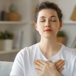 Propadlý hrudník: Co to znamená a jak ho napravit? 7 a person practicing deep breathing exercises with hands over chest, promoting relaxation and proper breathing techniques
