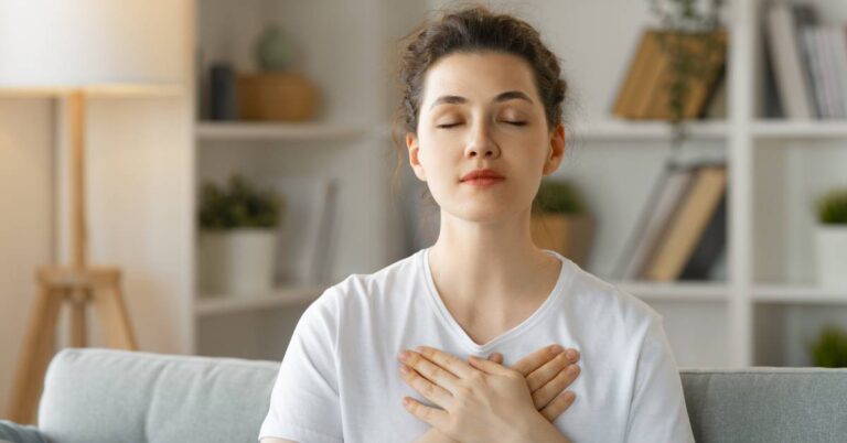 a person practicing deep breathing exercises with hands over chest, promoting relaxation and proper breathing techniques