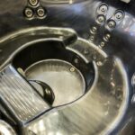 a close-up of a whirlpool bath’s drain cover and overflow system with visible jets and internal components