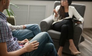a couple engaged in a serious discussion with a counselor in a relationship or partnerská poradna setting